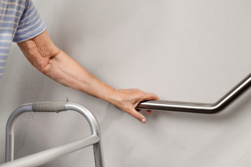 Elderly woman holding on handrail